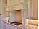Well-equipped kitchen with gas cooktop, custom range hood, and granite counters at 1525 Se 59Th St, Ocala, FL 34480