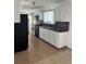 Kitchen with white cabinets, black appliances, and tile floor at 1 Willow Ct, Ocala, FL 34472