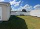 Backyard view showing a grassy area, white fence, and storage container at 1 Willow Ct, Ocala, FL 34472