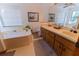 Bathroom features a large soaking tub, double vanity, and wood cabinets at 3630 Ne 67Th Ter, Silver Springs, FL 34488