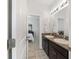 Clean bathroom with double vanity, granite countertop, and view of bedroom at 4710 Sw 65Th Pl, Ocala, FL 34474