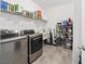 Bright laundry room with washer, dryer, and ample storage shelving at 4710 Sw 65Th Pl, Ocala, FL 34474