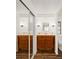 Bathroom with dual sinks, wood cabinets, and mirrored sliding doors at 903 Aloha Way, Lady Lake, FL 32159