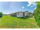 Mobile home with screened porch and a green lawn at 903 Aloha Way, Lady Lake, FL 32159