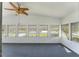 Sunroom with ceiling fan, grey carpet, and multiple windows at 903 Aloha Way, Lady Lake, FL 32159