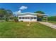 Mobile home with carport and a well-kept lawn at 903 Aloha Way, Lady Lake, FL 32159