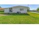 Mobile home with AC unit and spacious grassy yard at 903 Aloha Way, Lady Lake, FL 32159