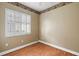 Well-lit bedroom featuring wood floors and window shutters at 9450 Se 130Th Place Rd, Summerfield, FL 34491