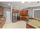 Modern kitchen with wood cabinets, granite counters, and tile floors at 9450 Se 130Th Place Rd, Summerfield, FL 34491