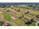 Aerial view of a golf course community with houses and a lake in the background at 9450 Se 130Th Place Rd, Summerfield, FL 34491