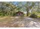 Small house with a covered front porch nestled amongst large trees at 10135 Se 108Th Terrace Rd, Ocala, FL 34472