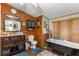 Bathroom featuring a clawfoot tub, wood-paneled walls, and dark wood vanity at 10135 Se 108Th Terrace Rd, Ocala, FL 34472