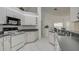 Kitchen with white cabinets, dark countertops, and appliances at 13552 Sw 81St Cir, Ocala, FL 34473