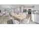 Kitchen and dining area with white cabinets, granite countertops, and wood-look flooring at 157 Fisher Ct, Ocklawaha, FL 32179