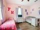 bedroom with twin bed and crib, decorated in pinks and purples at 227 Locust Pass Crse, Ocala, FL 34472