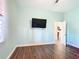 Simple bedroom with a wall-mounted TV and hardwood flooring at 227 Locust Pass Crse, Ocala, FL 34472
