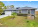 Gray house with white garage door, palm tree, and grassy yard at 227 Locust Pass Crse, Ocala, FL 34472