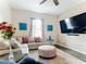 Gathering room with sectional sofa, large TV and hardwood floors at 227 Locust Pass Crse, Ocala, FL 34472