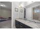 Bathroom with granite countertop, double sinks, and a view of the bedroom at 3993 Se 10Th Ave, Ocala, FL 34480