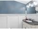 Elegant powder room with dark vanity and white wainscoting at 4535 Se 32Nd Pl, Ocala, FL 34480