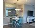 Charming dining area with a round table and four teal chairs at 10201 Sw 96Th Loop, Ocala, FL 34481