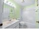 Clean bathroom with a shower/tub combo, vanity, and light green walls at 17789 Se 113Th Ter, Summerfield, FL 34491