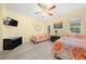 Bright bedroom with two twin beds, TV, and ceiling fan at 17789 Se 113Th Ter, Summerfield, FL 34491