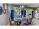 Bright dining room with a large table and blue accent curtains at 8563 Pinecrest Trl, Wildwood, FL 34785