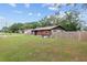 Side view of house, yard, and wooden fence at 1335 Ne 33Rd St, Ocala, FL 34479