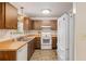 Bright kitchen with wood cabinets, white appliances, and a double sink at 1335 Ne 33Rd St, Ocala, FL 34479