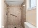 Bathroom with tiled shower, grab bar, and updated toilet at 1335 Ne 33Rd St, Ocala, FL 34479
