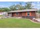 Ranch style home with brown siding, orange shutters, and rock accents at 1335 Ne 33Rd St, Ocala, FL 34479