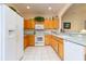 Kitchen with oak cabinets, white appliances, and a light and airy feel at 15659 Sw 13Th Cir, Ocala, FL 34473