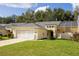 Single story home with a two-car garage and lush landscaping at 15659 Sw 13Th Cir, Ocala, FL 34473