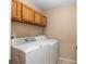 Laundry room with washer, dryer, and overhead cabinets at 3107 Ne 24 Pl, Ocala, FL 34470