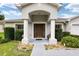 House entrance with columns, a brown door, and lush landscaping at 3107 Ne 24 Pl, Ocala, FL 34470