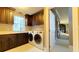 Well-appointed laundry room with dark wood cabinets, granite countertops, and modern washer/dryer at 7070 Se 14Th Ct, Ocala, FL 34480