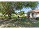 Large backyard with mature trees, grassy area, and partial view of neighboring homes at 9859 Sw 97Th St, Ocala, FL 34481