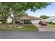 Brick ranch home with a two-car garage and a red car parked in the driveway at 9859 Sw 97Th St, Ocala, FL 34481