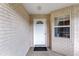 Front entry with white door and brick walls. Small window next to door at 9859 Sw 97Th St, Ocala, FL 34481