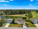 Aerial view showcasing a single-story house near a pond and golf course at 17855 Se 99Th Ave, Summerfield, FL 34491