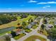 Aerial view of a house on a tree-lined street near a golf course at 17855 Se 99Th Ave, Summerfield, FL 34491