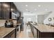 Modern kitchen with dark cabinetry, granite counters, and island at 141 Claire Ln, Davenport, FL 33837