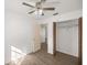 Bedroom with wood-look floors, ceiling fan, and access to closet and hallway at 78 Hemlock Dr, Ocala, FL 34472