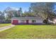 Single story home with red door and brick facade. Landscaped lawn and driveway at 78 Hemlock Dr, Ocala, FL 34472