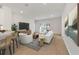Bright living room with hardwood floors, white furniture, and access to backyard at 7930 Sw 74Th Loop, Ocala, FL 34481