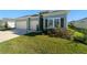 Single-story home with light blue siding, two-car garage, and landscaped lawn at 7930 Sw 74Th Loop, Ocala, FL 34481