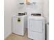 Bright laundry room with washer and dryer, and overhead shelving at 7930 Sw 74Th Loop, Ocala, FL 34481