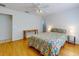 Bedroom with floral bedding, ceiling fan, and wood floors at 8943 Se 141St Loop, Summerfield, FL 34491