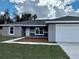 New construction home with gray exterior, stone accents, and a two-car garage at 90 Bay Dr, Ocklawaha, FL 32179